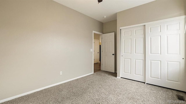 unfurnished bedroom with light carpet and a closet