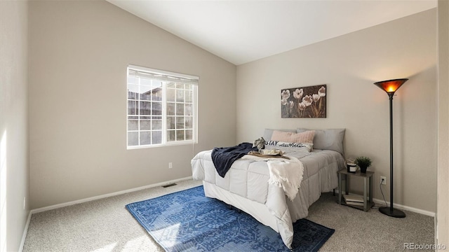 carpeted bedroom with lofted ceiling