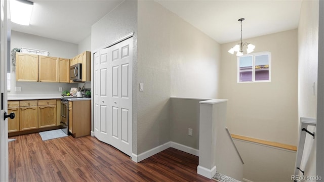 kitchen featuring appliances with stainless steel finishes, dark hardwood / wood-style flooring, hanging light fixtures, light brown cabinets, and an inviting chandelier