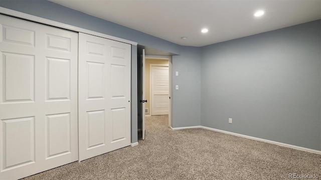 unfurnished bedroom with light colored carpet and a closet