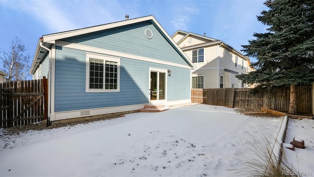 view of snow covered rear of property