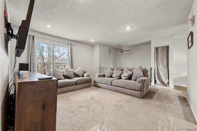 living room featuring light carpet, a textured ceiling, and ceiling fan