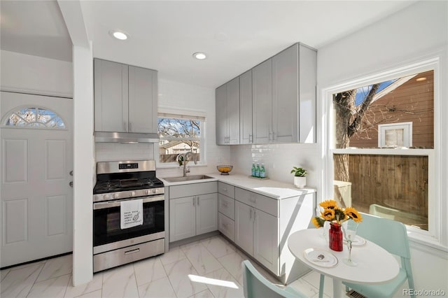 2570 Jay St, Edgewater, CO 80214 - kitchen with gray cabinets, stainless steel gas range oven, under cabinet range hood, light countertops, and recessed lighting