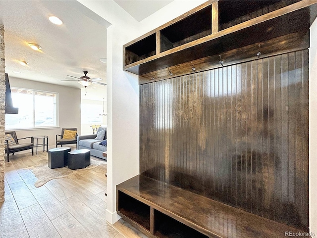 mudroom featuring ceiling fan, light hardwood / wood-style floors, and a textured ceiling