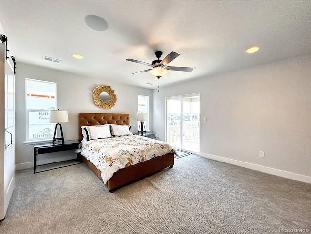 bedroom featuring a barn door, carpet floors, access to exterior, and ceiling fan