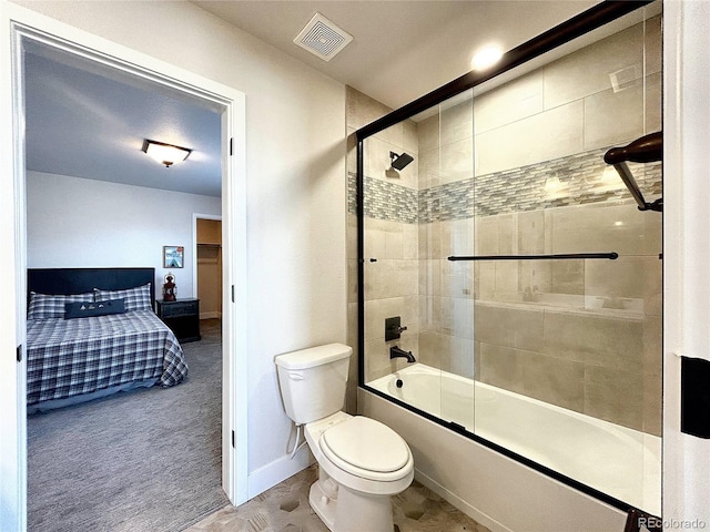 bathroom with toilet and bath / shower combo with glass door