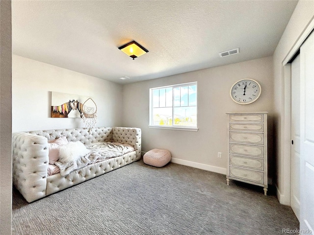 living area with a textured ceiling and carpet