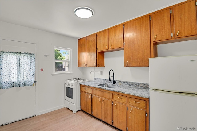 373 S Hazel Ct, Denver, CO 80219 - kitchen featuring white appliances, light wood finished floors, and brown cabinets