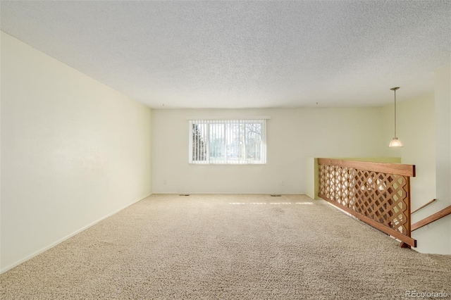 spare room featuring carpet and a textured ceiling