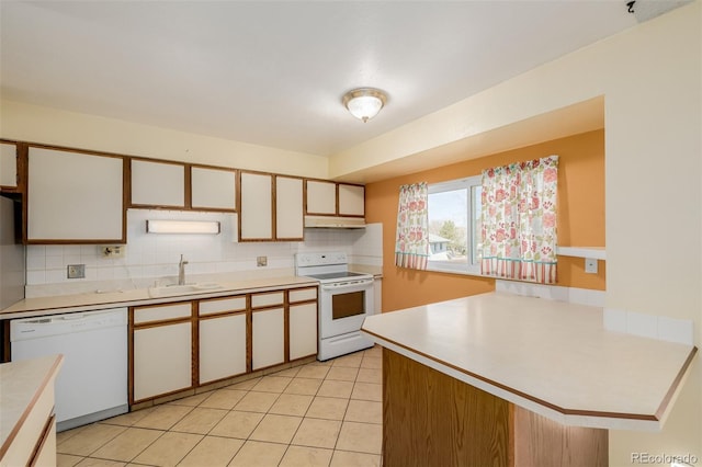 kitchen featuring tasteful backsplash, white appliances, light countertops, and a sink