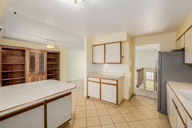 kitchen with light tile patterned floors, freestanding refrigerator, light countertops, and a ceiling fan