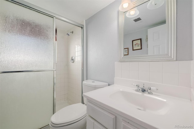 bathroom with visible vents, a shower stall, toilet, and vanity