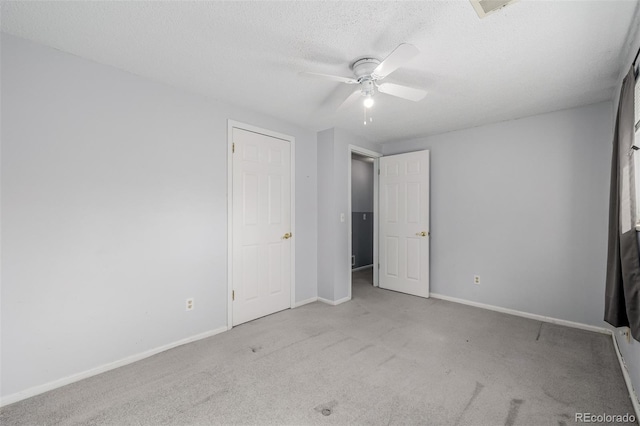 unfurnished bedroom with baseboards, carpet floors, a textured ceiling, and a ceiling fan