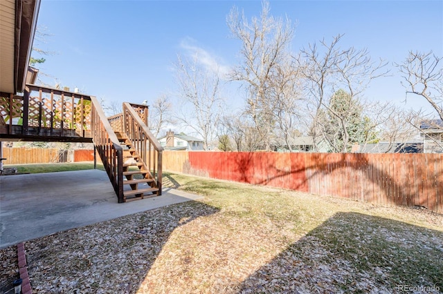 view of yard with a patio, a fenced backyard, and stairs