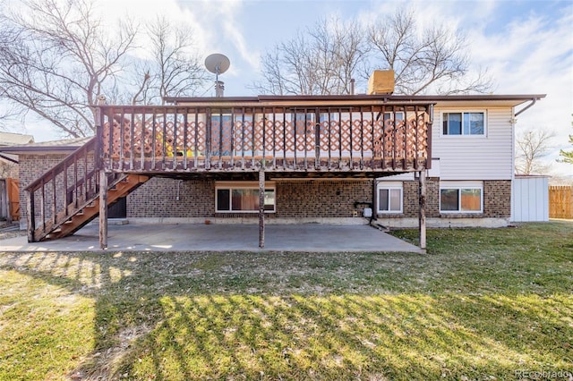 back of property featuring brick siding, a patio area, a lawn, and a wooden deck