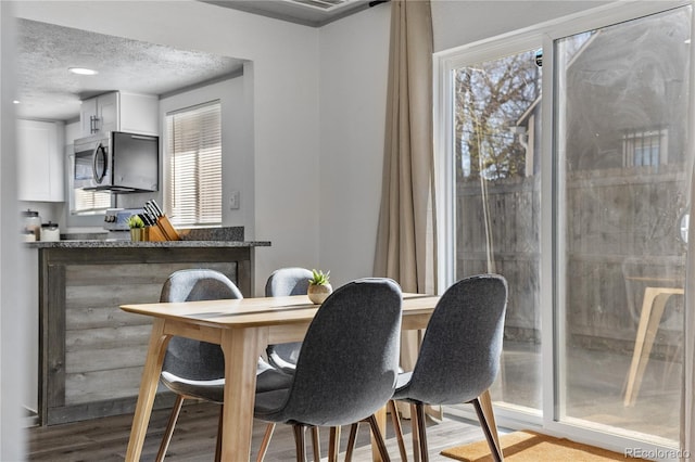 dining room with a textured ceiling and light hardwood / wood-style flooring