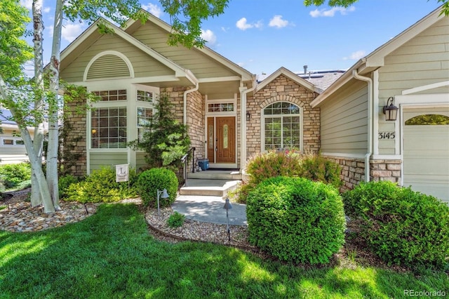3145 Stevens Cir, Erie, CO 80516 - view of exterior entry featuring stone siding and a garage