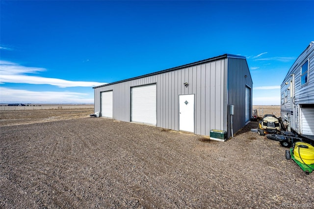 view of outbuilding with a garage and a rural view