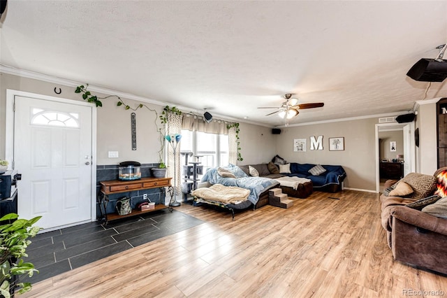 living room with wood-type flooring, ceiling fan, a textured ceiling, and crown molding