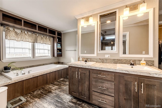 bathroom with vanity, a tub to relax in, crown molding, and hardwood / wood-style flooring