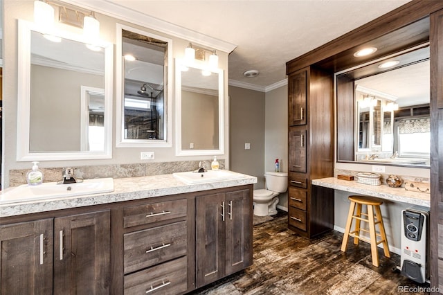 bathroom featuring crown molding, hardwood / wood-style flooring, vanity, heating unit, and toilet