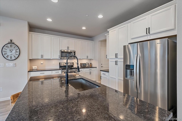 kitchen with white cabinetry, sink, and stainless steel appliances