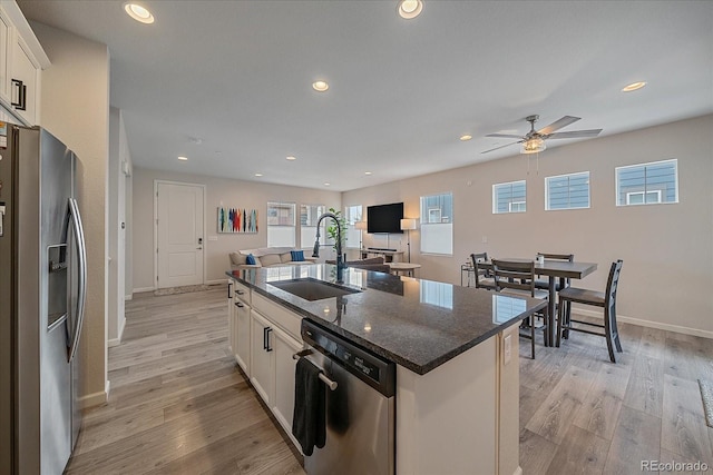 kitchen with appliances with stainless steel finishes, sink, a center island with sink, and white cabinets