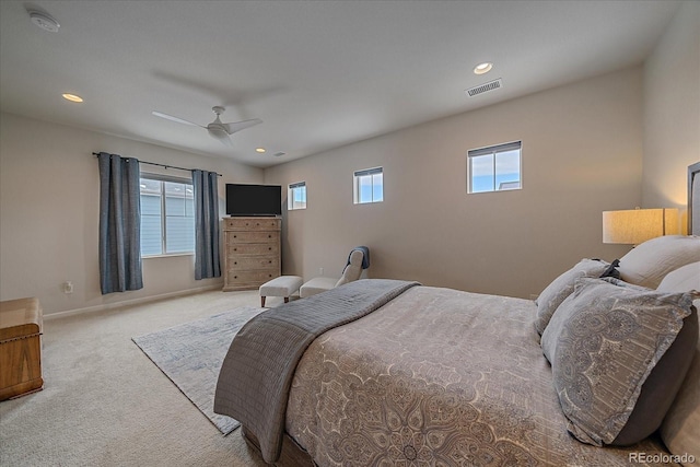 bedroom with multiple windows, light carpet, and ceiling fan