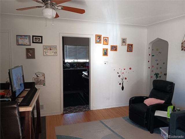 living area with hardwood / wood-style flooring and ceiling fan