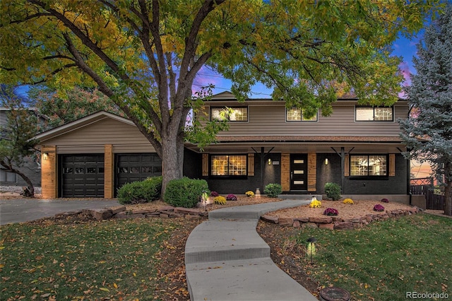 view of front of home featuring a yard, a porch, and a garage