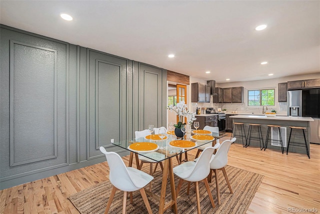 dining space with sink and light wood-type flooring