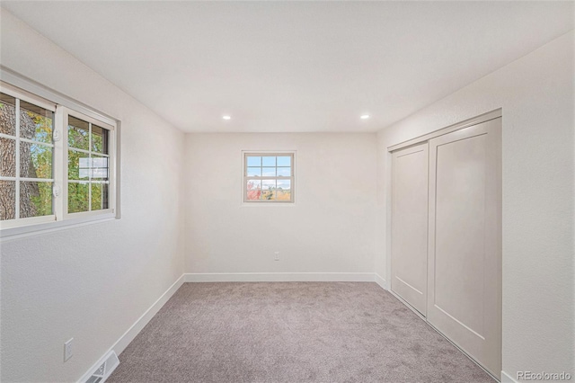 spare room with light colored carpet and plenty of natural light