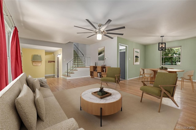 305 Titan St, Aurora, CO 80011 - living area featuring light wood-style flooring, stairway, baseboards, a chandelier, and ceiling fan