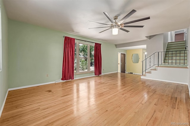305 Titan St, Aurora, CO 80011 - unfurnished living room with wood finished floors, ceiling fan, stairway, and baseboards