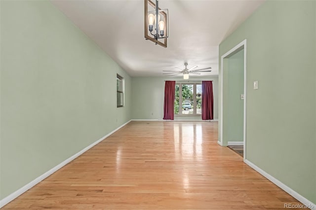 305 Titan St, Aurora, CO 80011 - spare room featuring light wood-type flooring, a chandelier, baseboards, and ceiling fan