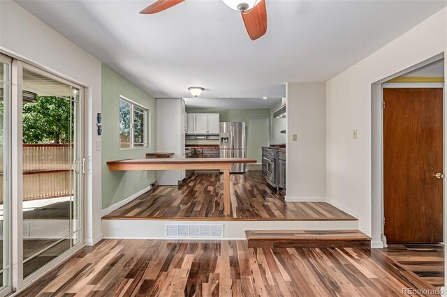 305 Titan St, Aurora, CO 80011 - unfurnished dining area featuring a ceiling fan, wood finished floors, and baseboards