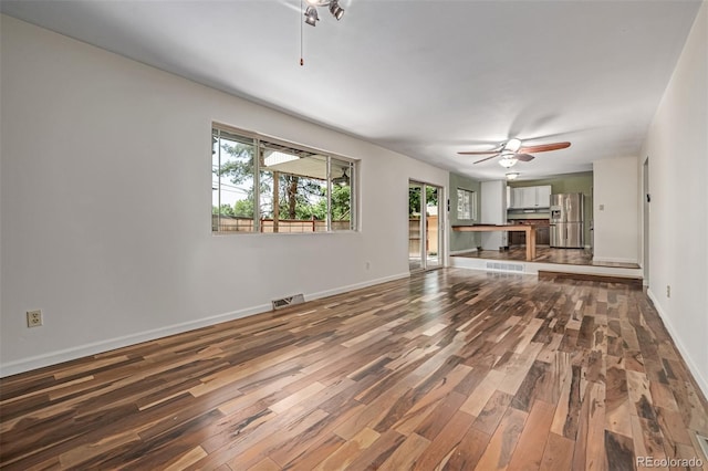 305 Titan St, Aurora, CO 80011 - unfurnished living room with wood finished floors, ceiling fan, and baseboards