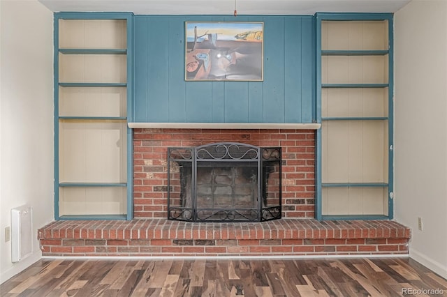 305 Titan St, Aurora, CO 80011 - detailed view of wood finished floors, baseboards, a brick fireplace, and built in shelves