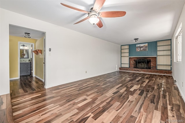 305 Titan St, Aurora, CO 80011 - unfurnished living room featuring wood finished floors, ceiling fan, a brick fireplace, and baseboards