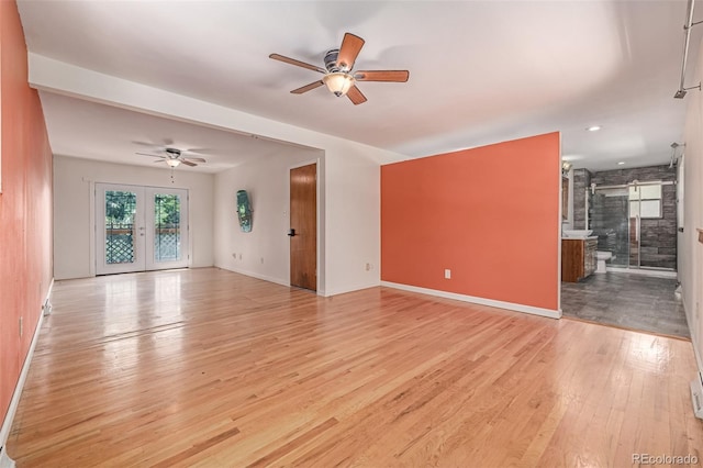305 Titan St, Aurora, CO 80011 - unfurnished living room featuring a ceiling fan, light wood-style flooring, and baseboards