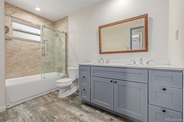 305 Titan St, Aurora, CO 80011 - full bathroom with toilet, double vanity, shower / bath combination with glass door, and wood finished floors