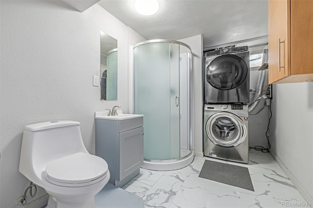 305 Titan St, Aurora, CO 80011 - bathroom with stacked washer and clothes dryer, a stall shower, vanity, marble finish flooring, and a textured ceiling