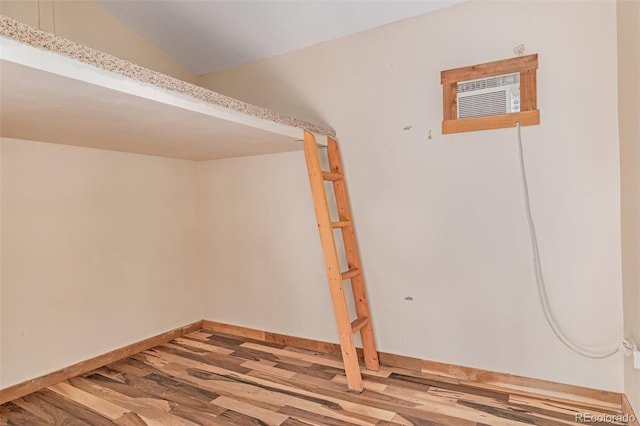 305 Titan St, Aurora, CO 80011 - basement featuring wood finished floors, baseboards, and a wall mounted AC