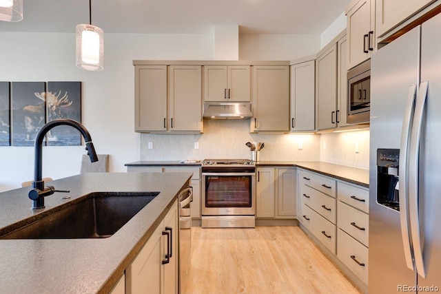 148 Hay Meadow Dr, Fraser, CO 80442 - kitchen featuring stainless steel appliances, under cabinet range hood, backsplash, pendant lighting, and light wood finished floors