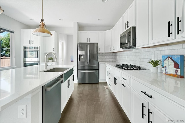 15378 W 50th Pl, Golden, CO 80403 - kitchen with stainless steel appliances, tasteful backsplash, white cabinets, decorative light fixtures, and dark wood-style floors
