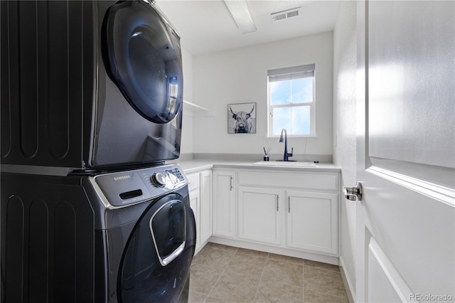 15378 W 50th Pl, Golden, CO 80403 - laundry area featuring estacked washer and dryer, cabinet space, and light tile patterned flooring