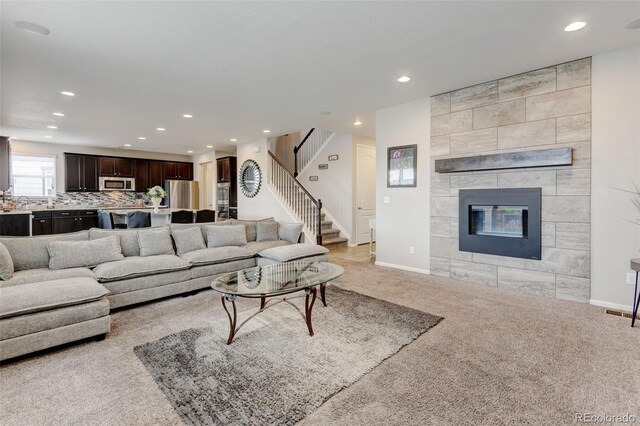 8071 Tabor St, Arvada, CO 80005 - living room with recessed lighting, light carpet, stairs, and a tile fireplace