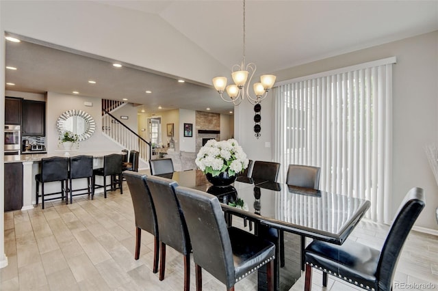 8071 Tabor St, Arvada, CO 80005 - dining space featuring a chandelier, lofted ceiling, stairway, light wood-type flooring, and recessed lighting
