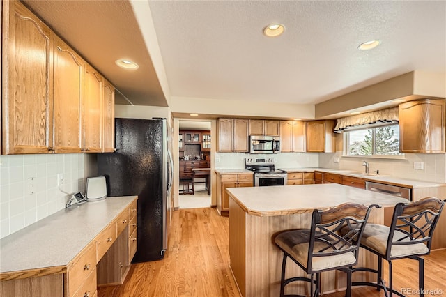 2369 Bayberry Ln, Castle Rock, CO 80104 - kitchen featuring stainless steel appliances, a sink, a breakfast bar area, tasteful backsplash, and recessed lighting