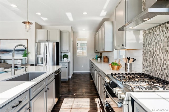 kitchen with wall chimney exhaust hood, stainless steel appliances, gray cabinets, and sink